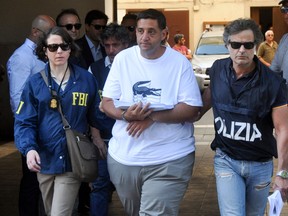 An FBI officer and Italian officer escort Thomas Gambino after he was arrested in Palermo during a police operation called 'New Connection' in Palermo on July 17, 2019.