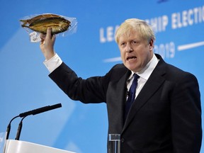 Conservative  leadership contender Boris Johnson holds up a kipper fish in plastic packaging as he speaks at the final Conservative Party leadership election hustings in London, on July 17, 2019.