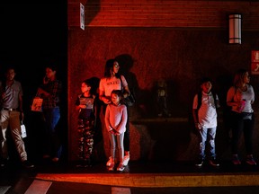 People wait at the parking of a shopping centre in Caracas on July 22, 2019 as the capital and other parts of Venezuela are being hit by a massive power cut.