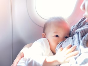 A woman breastfeeds her child while on a plane. Dutch airline KLM is under fire after a flight attendant told a breastfeeding mother to cover herself and her toddler up to avoid offending other passengers.