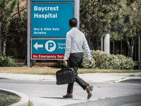 A pedestrian walks by Baycrest Hospital where some 150 employees have been terminated due to alleged benefits fraud.