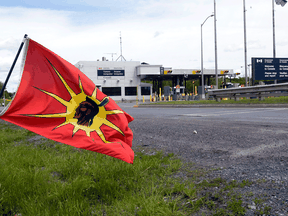A Mohawk Warrior flag flies in front of the Canadian border crossing station on Cornwall Island, Ont., during a protest in June 2009.