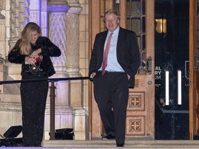 Boris Johnson passes Carrie Symonds as he leaves the Conservative party Black and White Ball at Natural History Museum on February 7, 2018 in London, England.