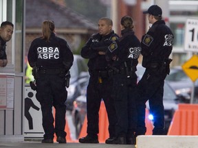 Members of the Canadian Border Services Agency gather at the Canadian border crossing in Surrey, B.C., Tuesday, Oct. 16, 2012. The Canada Border Services Agency is looking for a handful of stunt-actors to be thrown down, handcuffed, searched and beaten to help train new recruits.