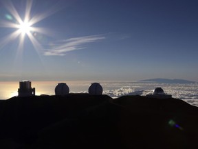The sun sets behind telescopes at the summit of Mauna Kea on July 14, 2019. Scientists are expected to explore fundamental questions about our universe when they use a giant new telescope planned for the summit of Hawaii's tallest mountain. The Union of B.C. Indian Chiefs says it stands in solidarity with mounting opposition to a giant telescope project in Hawaii. In an open letter to Prime Minister Justin Trudeau and Hawaii Governor David Ige, the organization calls for construction plans for what's known as the Thirty Meter Telescope project to be shut down and for the Canadian government to withdraw support for the project.