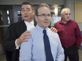 Glen Assoun, the Nova Scotia man who spent almost 17 years in prison for a crime he didn't commit, his lawyer Sean MacDonald and Ron Dalton, right, from the advocacy group Innocence Canada, stand outside Supreme Court in Halifax on Friday, July 12, 2019. Nova Scotia's justice minister says he's waiting for a ruling on whether he has a conflict of interest before commenting on revelations that the RCMP erased evidence in the case of a man wrongfully convicted of murder.