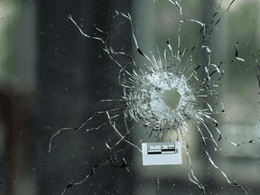 A bullet hole through a glass window is seen at Pappas Grill on Danforth Avenue in Toronto the day after a mass shooting on July 22, 2018.