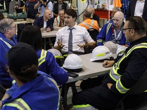 Prime Minister Justin Trudeau speaks with workers at the Trans Mountain Terminal in Edmonton on Friday, July 12, 2019.