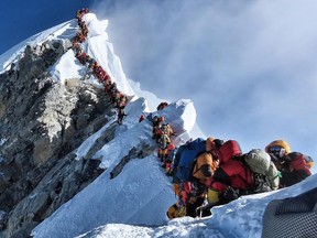 This handout photo taken on May 22, 2019 and released by @nimsdai Project Possible shows heavy traffic of mountain climbers lining up to stand at the summit of Mount Everest.