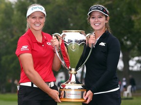Brooke Henderson with the champion’s trophy along with her sister and caddie, Brittany, following the final round of the 2018 CP Women’s Open at the Wascana Country Club in Regina, Sask.