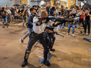 A riot police officer holds a shotgun towards protestors during a demonstration on July 30, 2019 in Hong Kong.