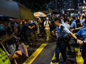 Police officers form a ring around Rupert Dover, the Hong Kong police chief superintendent, during a protest near the Canton Road tourist shopping district in Hong Kong, July 7, 2019.