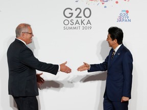 Australian Prime Minister Scott Morrison (L) is welcomed by Japanese Prime Minister Shinzo Abe upon his arrival for a welcome and family photo session at G20 leaders summit on June 28, 2019 in Osaka, Japan.