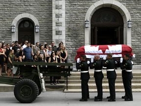 Mourners stand on the steps of the Paroisse Saint-Gregoire-de-Nazianze as the casket of Bombardier Patrick Labrie is carried inside, following a military funeral procession in the Gatineau community of Buckingham.