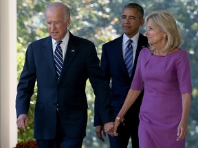 U.S. Vice President Joe Biden, followed by U.S. President Barack Obama, holds hands with his wife Jill Biden while walking to the Rose Garden in October 2015.