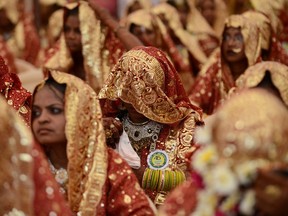 An Indian Muslim bride has her face covered with her wedding sari during a mass wedding ceremony at the ancient Sarkhej Roja in Ahmedabad on February 22, 2013. The Indian government passed a bill Tuesday outlawing the practice of 'Triple Talaq' which gives Muslim men the freedom to divorce their wives instantaneously.