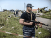 Armed pro-Russian separatists stand guard in front of the crash site of Malaysia Airlines Flight MH17, near the village of Grabove, on July 20, 2014.