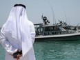 An Emirati official watches members of the U.S. Navy Fifth Fleet as they prepare to escort journalists to tanker at a U.S. NAVCENT facility near the port of Fujairah, United Arab Emirates June 19, 2019.