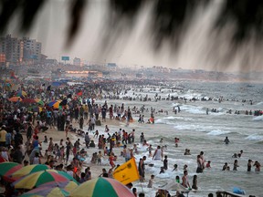 Palestinians enjoy themselves along the shore of the Mediterranean Sea as they escape from the summer heat, in Gaza City on June 28, 2019.