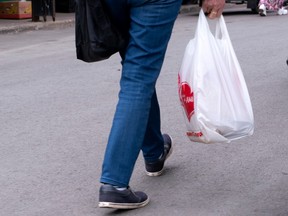 A woman carries a plastic bag at a market in Montreal on June 13, 2019. British Columbia's top court has quashed a bylaw prohibiting single-use plastic bags in Victoria, saying the city failed to get the approval of the province's environment minister.