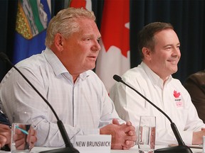 Ontario Premier Doug Ford speaks to media while Alberta Premier Jason Kenney looks on. The Premiers were in Calgary for the annual Premier's Stampede pancake breakfast held at McDougall Centr. Monday, July 8, 2019. Dean Pilling/Postmedia