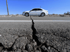 A car drives past a crack in the road on Highway 178, south of Trona, after a 6.4-magnitude earthquake hit in Ridgecrest, California, on July 4, 2019. A 7.1 magnitude quake hit the state on July 6.