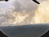 A view through an aircraft window shows smoke from wildfires rising above the Zhigansky district of the Republic of Sakha (Yakutia), Russia.