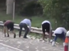 People bend down to take cash from the armoured truck on the side of a Georgia  highway.