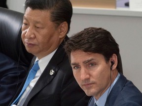 Prime Minister Justin Trudeau and Chinese President Xi Jinping listen to opening remarks at a plenary session at the G20 Summit in Osaka, Japan, on June 28, 2019.