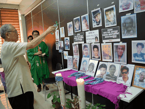 Retired Catholic Bishop Nicanor Yniguez blesses the portraits of victims of extrajudicial killings during a memorial mass at the Philippine Human Rights Commission office in Manila on July 9, 2019.