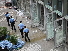 Police walk next to the Legislative Council building in Hong Kong on July 2, 2019, a day after protesters broke into the building. Hong Kong's leader on July 2 condemned "the extreme use of violence" by masked protesters who stormed and ransacked the city's legislature in an unprecedented challenge to Beijing's authority.