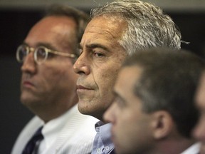 In this July 30, 2008 file photo, Jeffrey Epstein, centre, is shown in custody in West Palm Beach, Fla. The wealthy financier and convicted sex offender has been arrested in New York on sex trafficking charges. Two law enforcement officials said Epstein was taken into federal custody Saturday, July 6, 2019, on charges involving sex-trafficking allegations that date to the 2000s.