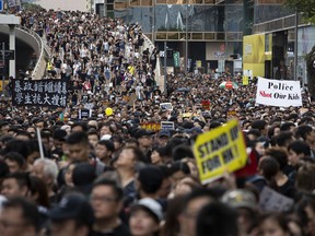 Demonstrators hold placards as they march along Canton Road during a protest in the Tsim Sha Tsui district of Hong Kong, China, on Sunday, July 7, 2019. Hong Kong police arrested five people while dispersing a protest Sunday in one of the financial hub's busiest tourist districts, the latest demonstration triggered by a proposed law that would allow extraditions of criminals to mainland China for the first time.
