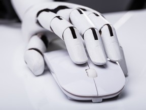 Close-up Of A Robotic Hand Using Computer Mouse