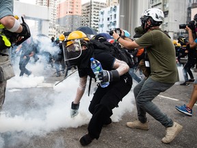 Demonstrators throw back tear gas canisters during a protest in the Yuen Long district of the New Territories in Hong Kong, China, on Saturday, July 27, 2019.