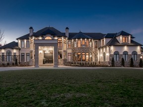 The custom residence has impressive double wood doors that open onto a wow foyer.