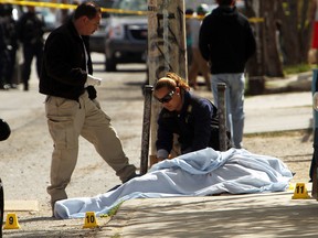 A murder victim is handled by police on March 20, 2010 in Juarez, Mexico.