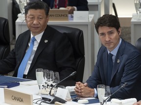 Prime Minister Justin Trudeau and Chinese President Xi Jinping listen to opening remarks at a plenary session at the G20 Summit in Osaka, Japan, on June 28, 2019.