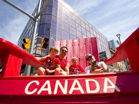 Kris and Jessica Witka, pose for a photo with their two sons Mason, 5 and Morgan 2, in the big Canada lawn chair set up on London's flex street for Canada Day. Photograph taken on Monday July 1, 2019.