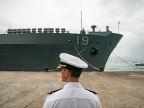 A navy crew member stands guard in front of the USS Blue Ridge at a wharf during a port call on April 20, 2019 in Hong Kong, China.