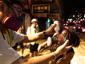 A medic gives an eye wash to a protester after police fired tear gas during a demonstration on Hungry Ghost Festival day outside a police station in Sham Shui Po district on August 14, 2019 in Hong Kong, China.