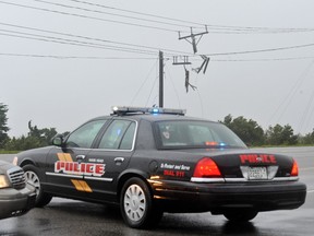 Police cars stand near a damaged power line in Nag's Head on August 27, 2011.