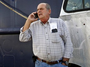 Carlos Rafael talks on the phone at Homer's Wharf near his herring boat.