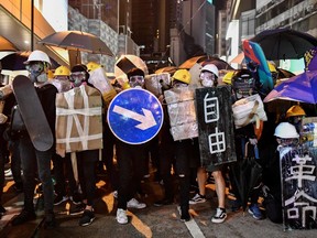 Protesters hold makeshift shields, including a road sign and a skateboard, during clashes with police at a demonstration in Hong Kong on July 28, 2019