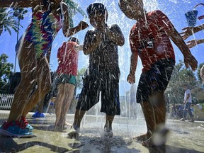 In this file photo taken on July 27, 2019, children cool off at a water park in Alhambra, California as southern California endures another summer heatwave with triple-digit temperatures.