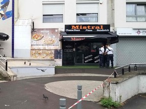Policemen stand in front of the eatery where a waiter was shot dead by a customer allegedly angry at having to wait for a sandwich, in the eastern Paris suburb of Noisy-le-Grand on August 17, 2019.