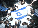 Students gather around an Israeli flag at an anti-hate rally in Toronto.