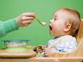 A person feeds their baby dinner. Experts say it is possible to raise a baby on a vegan diet with proper guidance and research.