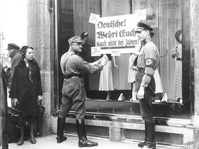 In 1930s Germany, Jewish people were accused of being traitors and the Nazis used charges of disloyalty to justify their persecutions and mass killings. Here, Nazis post signs on a Jewish store in Berlin warning Germans not to buy from Jews.