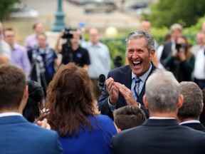 Premier Brian Pallister claps for his Progressive Conservative team during a press conference behind the Manitoba Legislative Building after dropping the writ on Mon., Aug. 12, 2019.